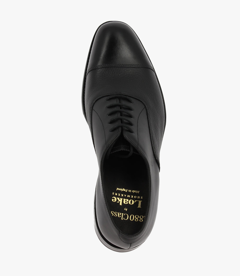 This photo captures one Loake Fullerton shoe from a top-down perspective, focusing on the rich black leather and the elegant toe cap design. The contrast between the smooth leather and the subtle shine from the hand-polished finish emphasizes the shoe's luxurious appeal, perfect for formal occasions.