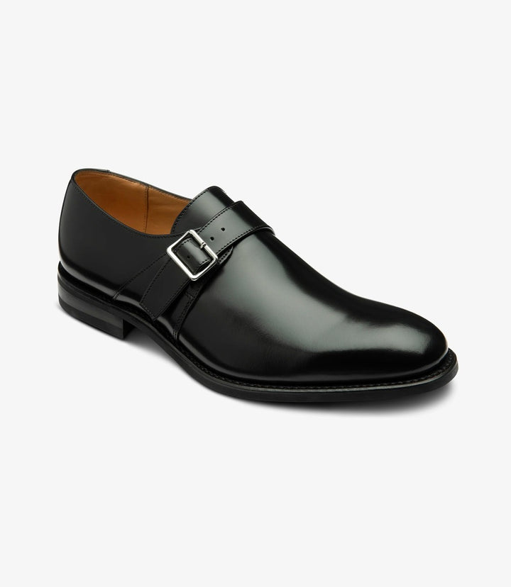 The shoe is captured at a slight angle, highlighting the elegant curvature from the toe cap to the heel. The angle showcases the shine of the polished leather, the precise stitching along the welt, and the low-profile heel, offering a refined yet modern look.