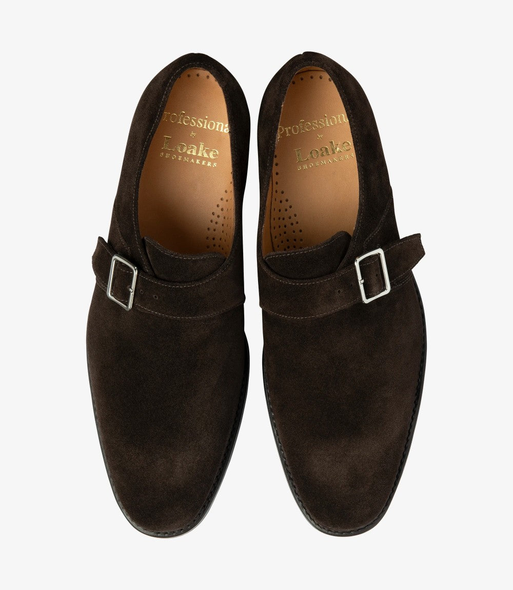 Both shoes are captured from above, revealing the symmetrical design of the monk straps and toe caps. The suede texture is clearly visible, along with the inner leather lining, giving a sense of the shoe's quality craftsmanship and comfortable interior.