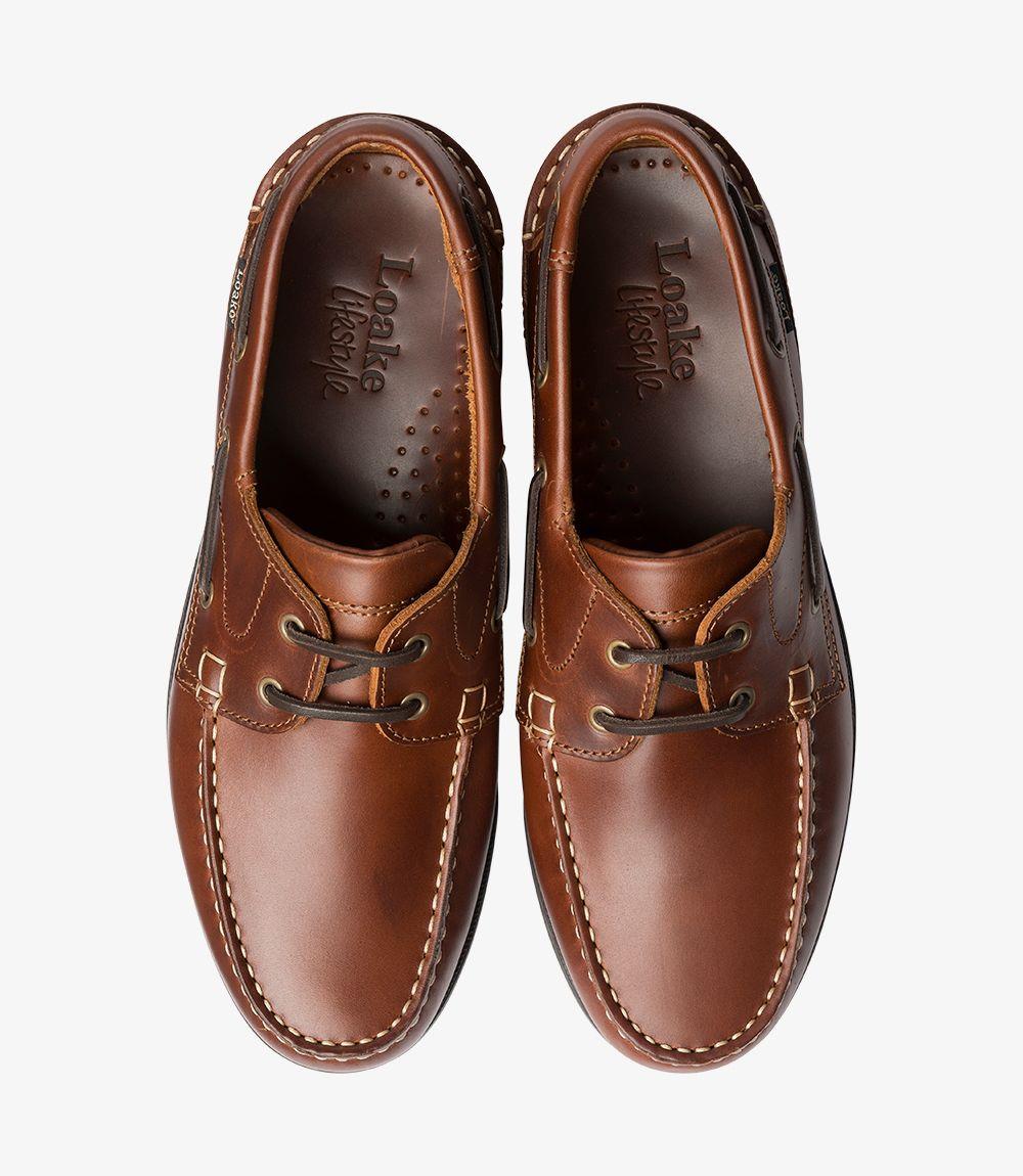 A top view of the pair of Loake 524-DIS Brown Boat Shoes, displaying the smooth brown leather and the classic lacing system. The interior leather lining is partially visible, emphasizing the shoe's quality craftsmanship. The symmetry and fine details of both shoes are highlighted, making them an ideal choice for casual summer wear.