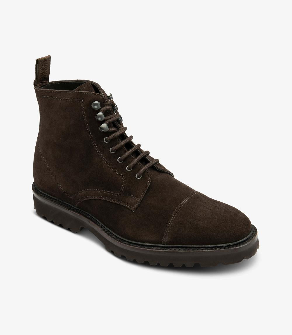 The Loake Aquarius Derby Boot is presented from an angle, emphasizing its refined design and the seamless transition between the suede upper and the robust sole. The rounded toe shape enhances the boot's classic aesthetic, while the luxurious leather lining is subtly visible, hinting at the comfort within.