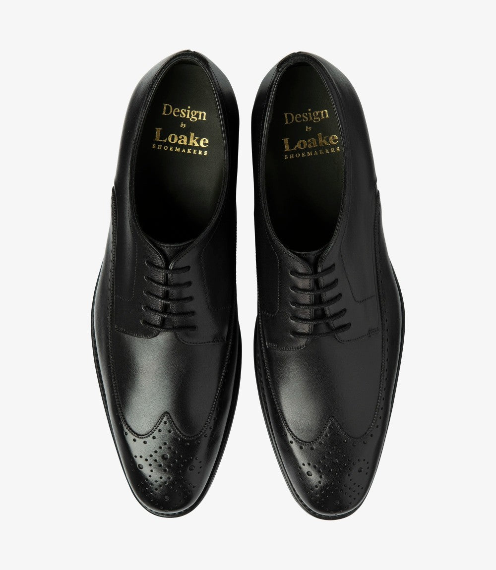 Viewed from above, the pair of Loake Bale Black Derby Brogues exhibits their stylish symmetry. The classic Derby lace-up design is highlighted, along with the distinct brogue perforations that add character. The polished black leather shines under the light, reflecting the meticulous craftsmanship, while the comfortable leather insoles are subtly suggested, indicating the luxurious feel inside.