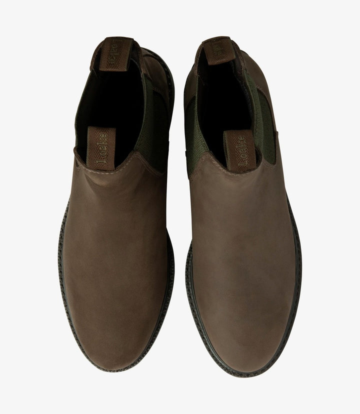 The top-down perspective displays both Loake Ducksworth Chelsea Boots side by side. The rich brown of the oiled nubuck leather is prominent, emphasizing the boots' polished appearance. The elastic side panels are visible, framing the boots elegantly, while the comfort footbed is suggested by the soft contours of the inner lining. The cemented rubber soles are clearly seen, highlighting the boots' robust construction and stability.