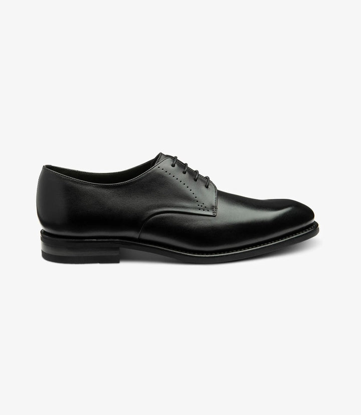 The side profile of the Loake Gosling Black Derby Shoes showcases their sleek and polished silhouette. The rich black calf leather gleams under the light, highlighting the elegant design. The Goodyear welted shadow rubber sole is subtly visible, indicating durability and quality craftsmanship.