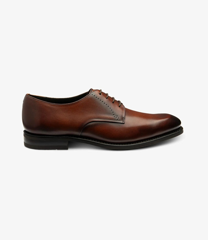 The image captures the sleek silhouette of the Loake Gosling Scotch Derby Shoes from the side. The smooth calf leather shines in a rich scotch hue, showcasing the shoe's elegant lines and stitching details. The Goodyear welted shadow rubber sole adds a touch of sophistication while ensuring durability.