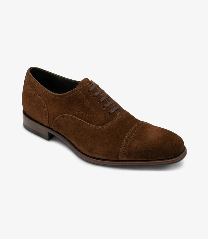 This image captures the shoe from an angle, emphasizing the sleek contours and the subtle sheen of the hand patina calf leather. The stitching detail along the edge of the sole is visible, showcasing the craftsmanship involved in creating this premium men's shoe. The bold toe shape is accentuated, giving the shoe a modern yet timeless appeal.