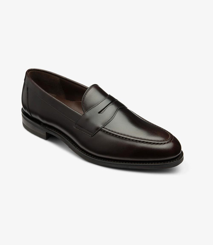 From this angle, the Imperial Dark Brown Loafer reveals its stylish contours, emphasizing the expertly crafted shape and the luxurious waxy leather finish. The elegant curve of the toe blends seamlessly into the apron design, while the contrasting shadow rubber sole highlights the shoe's robust construction. This perspective showcases the meticulous attention to detail, from the clean stitching to the comfortable fit, making it evident that this loafer is both a practical choice and a statement piece.