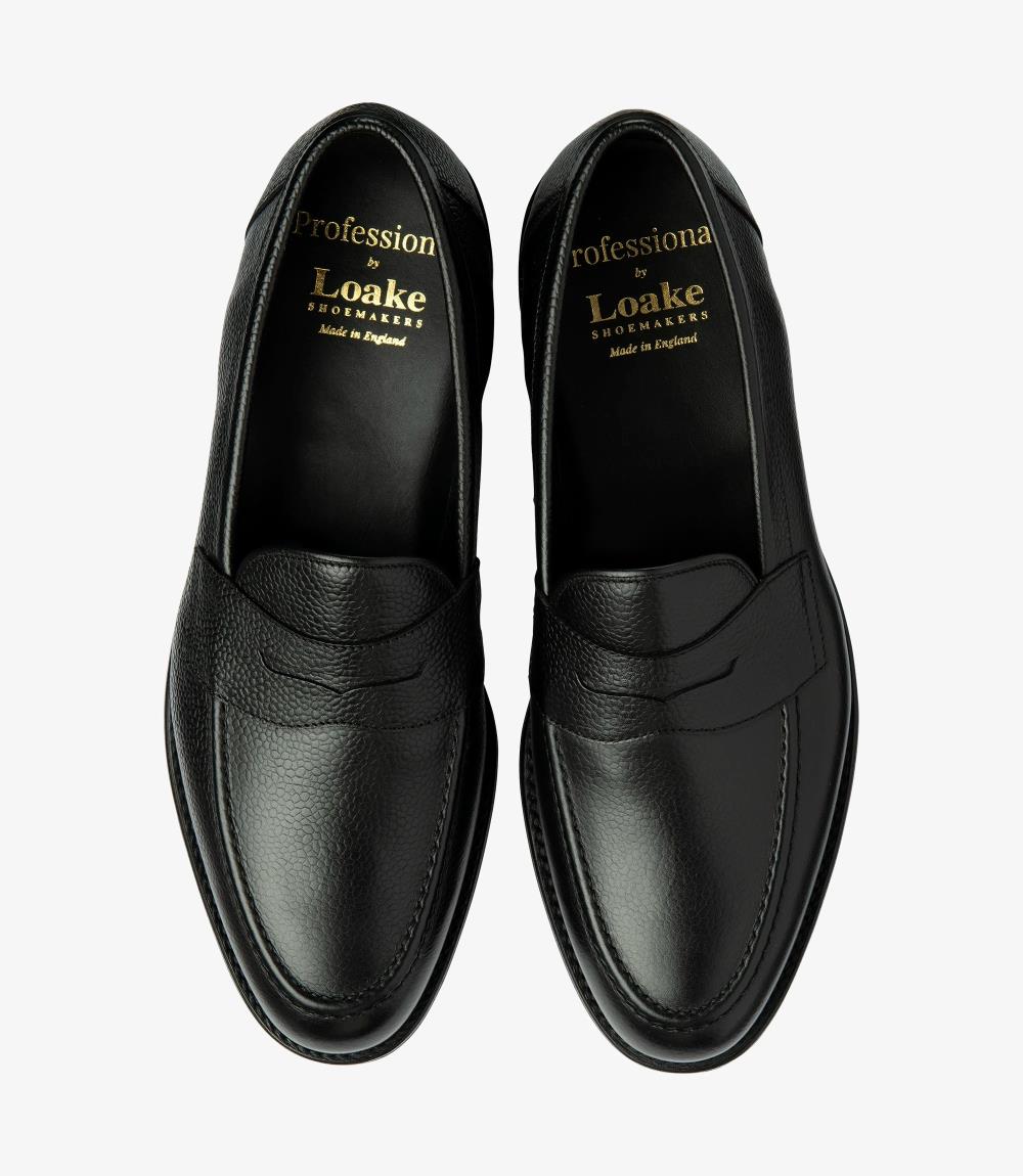 The overhead view of the Imperial Grain Black Loafers displays both shoes side by side, providing a comprehensive look at their sophisticated design. The polished grain calf leather surfaces reflect a deep, lustrous black tone, while the classic penny loafer style is highlighted by the distinctive cutout. The cushioned insoles are slightly visible, hinting at the comfort that awaits with each step. 