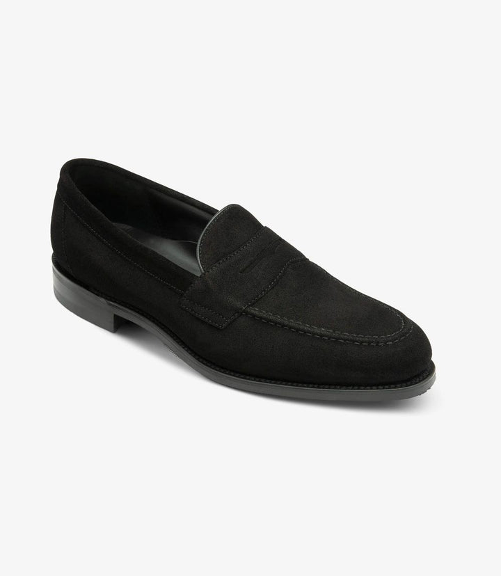 From this angle, the Imperial Suede Black Loafer reveals its stylish contours and expertly crafted shape. The rich black suede exudes luxury and elegance, with subtle highlights that catch the light. The classic apron design is accentuated by delicate stitching details, while the shadow rubber sole is visible, hinting at the shoe's robust construction. This view accentuates the loafer’s smooth lines and refined appearance, showcasing its blend of practicality and sophistication.