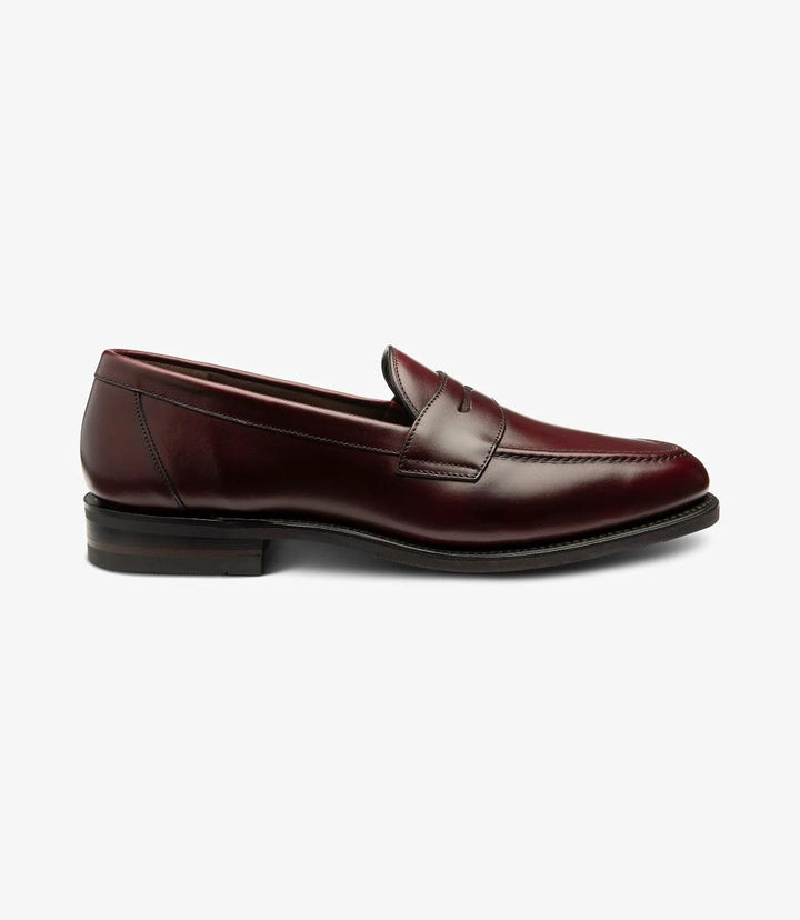 The side view of the Imperial Burgundy Loafer showcases its elegant silhouette and polished leather finish. The shoe’s sleek lines and refined profile emphasize its classic design, highlighted by the subtle stitching along the apron. The Goodyear welted sole is visible, reflecting its durability and quality craftsmanship. This angle captures the luxurious burgundy hue, making it a standout piece in any gentleman’s collection. 