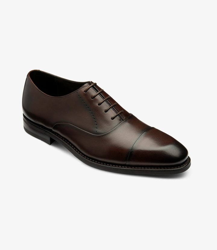 In this angled shot, the shoe is presented with a slight tilt, highlighting the contours and stitching details of the upper. The classic lines of the shoe are complemented by the subtle sheen of the leather. The angle captures the depth of the toe cap and the comfortable fit, making it an appealing choice for formal attire.