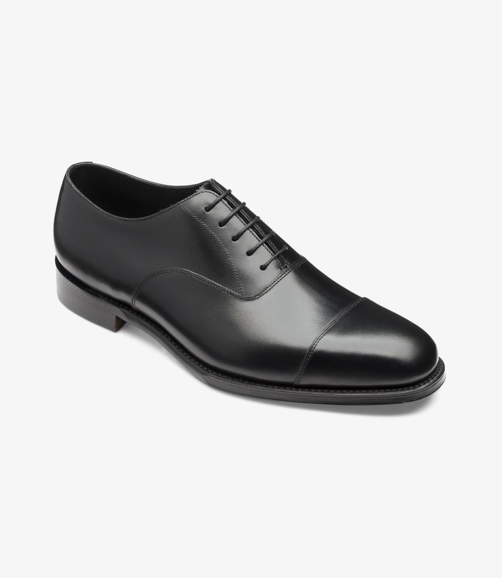 This image captures the Aldwych Oxford shoes from an angled side perspective, showcasing the elegant curvature of the shoe. The toe cap design is clearly visible, accentuating its refined aesthetic. The Dainite rubber sole peeks out from beneath, hinting at the shoe’s practicality and durability. The laces are neatly tied, contributing to the overall polished appearance.