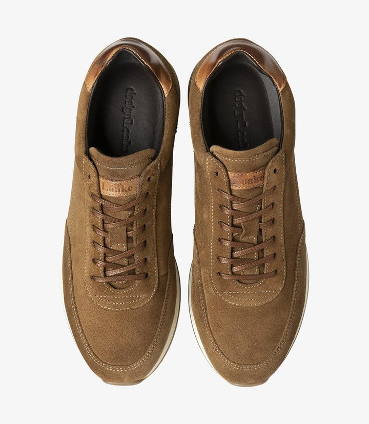 From the top view, both Loake Bannister Tan Suede Trainers are aligned symmetrically, showcasing their stylish design. The soft suede texture and subtle stitching details are clearly visible, contributing to the shoe's overall sophistication. The laces are neatly tied, with the eyelets providing a secure fit. This view highlights the generous fit of the trainers, making them a comfortable choice for everyday wear.