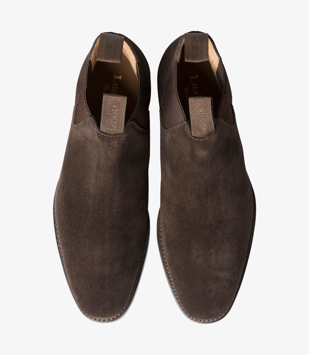 This overhead shot displays the Loake Chatsworth Chelsea Boot, focusing on its smooth, dark brown suede finish. The classic Chelsea boot design is evident, with the elastic side panels framed by the boot’s upper. The rounded toe offers a sleek profile, while the leather insole can be glimpsed through the opening, hinting at the comfort and quality within.