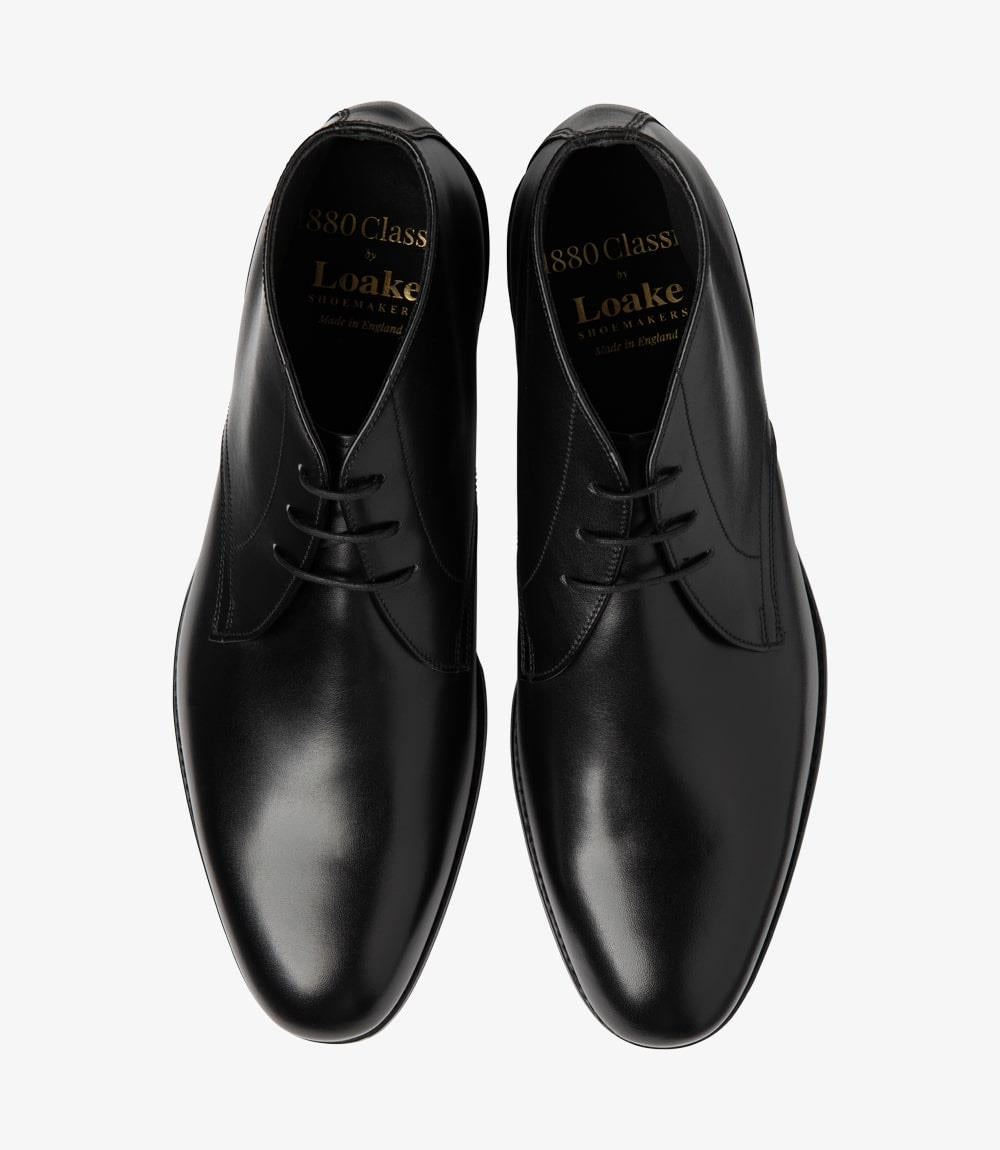 This overhead view captures the Loake Deangate Black Chukka Boot in its entirety, emphasizing its refined lines and silhouette. The lacing is neatly done, centered along the top, showcasing the boot's structured design. The soft leather upper appears both durable and inviting, while the leather insoles promise comfort with every step. The rounded toe shape is evident, aligning perfectly with the boot's classic aesthetic. 