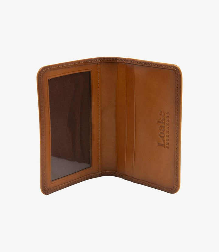 In the open view, the Loake Fenchurch Tan Wallet reveals its thoughtfully designed interior. The wallet features five card slots, with four neatly arranged inside and one positioned for easy access on the outside. The clear plastic ID section is prominently displayed, allowing for quick identification. The interior showcases the same premium tan leather, highlighting the craftsmanship and attention to detail. 