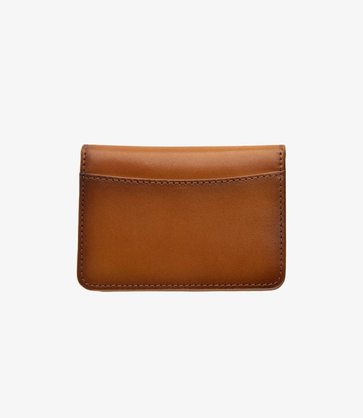 The closed view of the Loake Fenchurch Tan Wallet showcases its sleek and sophisticated design. Crafted from luxurious tan calf leather, the wallet features a smooth, polished finish that reflects light beautifully. The subtle embossed Loake logo adds a touch of elegance to the front, emphasizing the quality of this men's accessory. Its compact size allows it to fit comfortably in your hand, making it an ideal choice for everyday carry