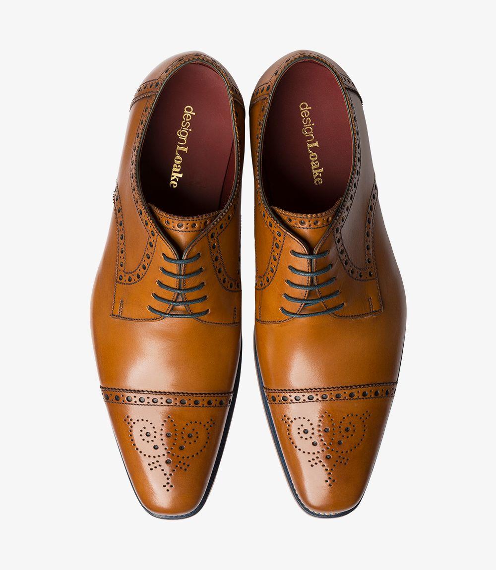 Viewed from above, the Loake Foley Tan Derby Semi Brogue reveals its refined construction and attention to detail. The symmetrical design features a classic lacing system that elegantly runs down the center, framed by the beautifully finished leather. The two shoes side by side illustrate their harmonious design and the rich tan color, making them an eye-catching addition to any footwear collection.