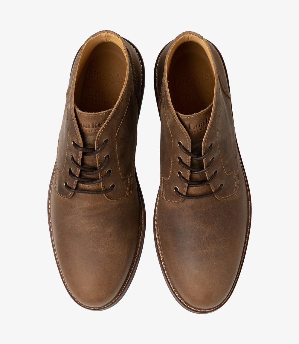 The top-down view of both chukka boots reveals the symmetrical design and the luxurious quality of the leather. The laces are neatly tied, and the interior of the boots can be seen, highlighting the fully leather-lined interior that promises comfort. The paired boots are positioned to exhibit their complementary appearance, making them perfect for stylish coordination.