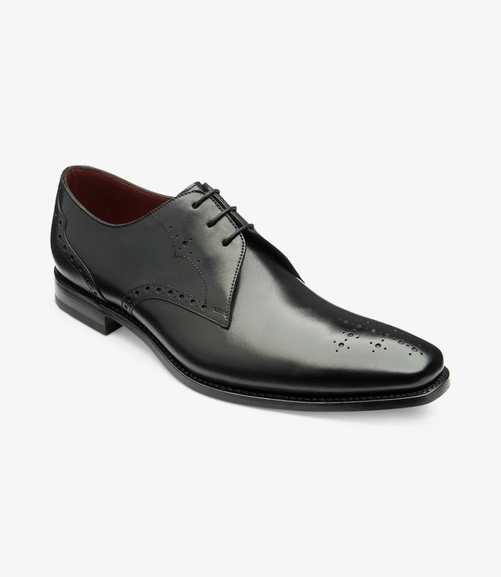 This angle highlights the Derby's contours, allowing a glimpse of the front and side. The unique punched toe design is more pronounced, adding character to the shoe. The leather's grain and sheen are evident, reflecting its premium quality. The sturdy leather sole, with its slight curvature, suggests both comfort and durability, perfect for formal occasions or everyday wear.