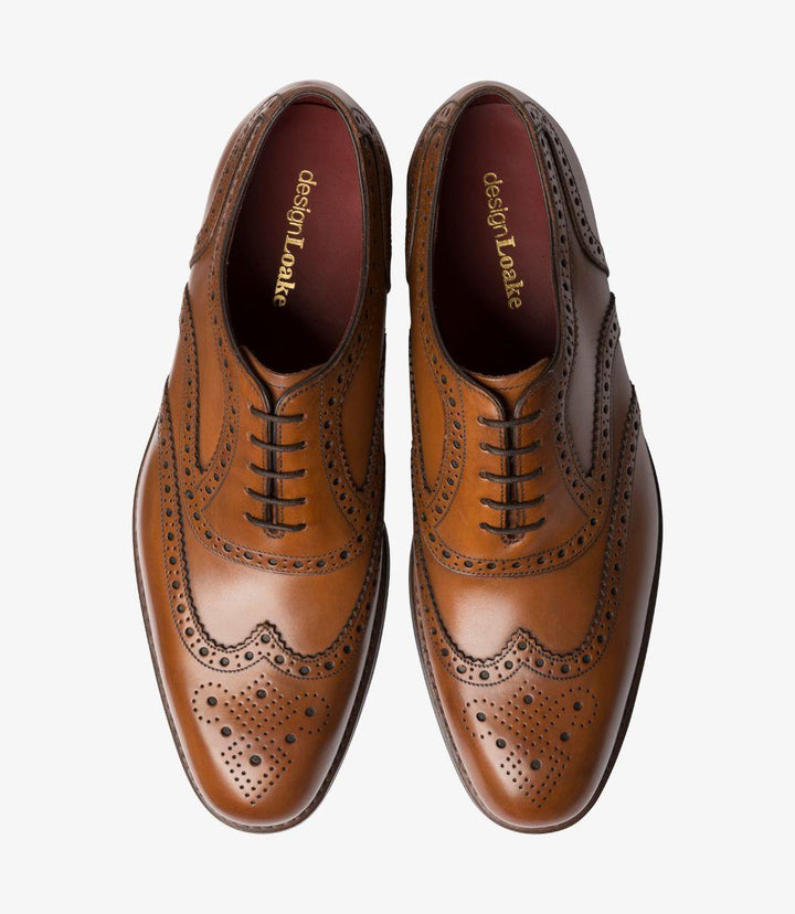 From above, the pair of Kerridge Cedar Oxfords reveals their symmetrical brogue detailing across the toe caps, complemented by traditional Oxford lacing that emphasizes the shoe’s classic design. The warm cedar leather is polished to a smooth, even finish, while the subtle elongation of the toe enhances its refined look. The fully leather-lined interiors peek out, showcasing the shoe’s high-quality craftsmanship and commitment to comfort.