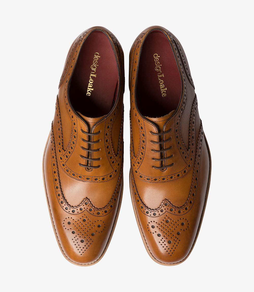 Seen from above, the pair of Kerridge Tan Oxfords display symmetrical broguing along the toe caps, with classic Oxford lacing that accentuates the shoe’s traditional design. The warm tan leather has a smooth, polished finish, while the subtle elongation in the toe adds a graceful dimension. Fully leather-lined interiors peek out, underscoring the high-quality craftsmanship and attention to comfort in each pair.