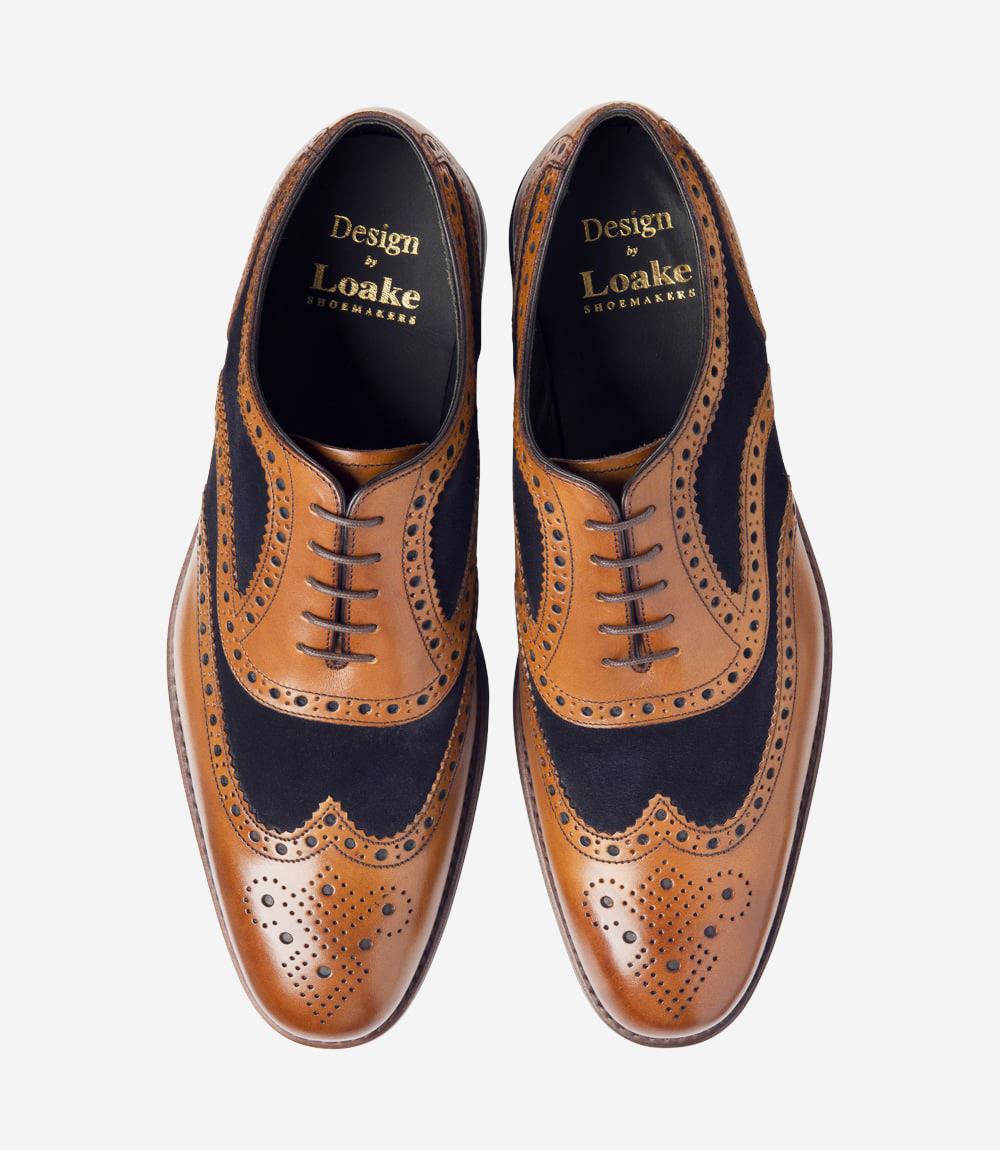 From above, the pair of Loake Kerridge shoes reveal their symmetrical Oxford lacing and precise brogue detailing across the toe caps. The tan and navy tones blend harmoniously, with a smooth, polished finish on the leather. The toe caps and quarters are carefully shaped, with the subtle elongation of the Claridge last giving them a stylish and balanced appearance. The insides are fully leather-lined, offering a glimpse of the refined craftsmanship that defines each pair.