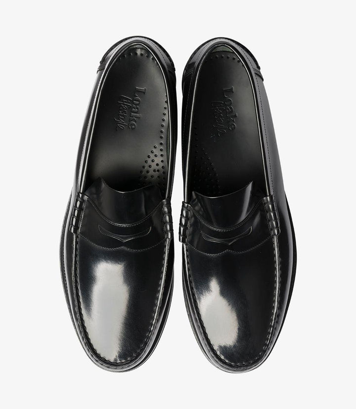 The top view of the Loake Princeton Black Loafer provides a clear look at its overall design and structure. The smooth, polished surface of the leather is prominent, with the beef-roll detailing creating a stylish focal point. The shoe’s opening is neatly shaped, offering an inviting look for easy slip-on access. The rounded toe is clearly visible, showcasing the well-balanced proportions of the loafer. This perspective highlights the loafer's versatility, suitable for various outfits and occasions.