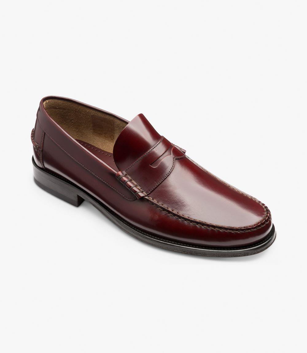 From this angled perspective, the Loake Princeton Burgundy Loafer reveals its craftsmanship and attention to detail. The smooth leather upper transitions seamlessly to the flexible leather sole, emphasizing the moccasin construction. The beef-roll detail adds dimension to the design, while the rounded toe provides a contemporary look. This view captures the shoe's elegant profile, showcasing its suitability for both casual and formal settings.