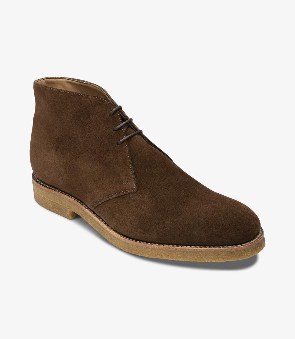 From this angle, the distinctive design elements of the Rivington boot are prominently displayed. The bold toe shape of the '026' last creates a contemporary look, while the subtle curvature of the upper enhances its sophistication. The seamless transition from the suede upper to the crepe sole emphasizes the boot's quality construction, making it an ideal choice for both formal and casual occasions.