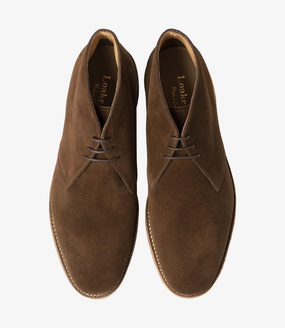 The top view of the Loake Rivington Brown Chukka Boot reveals its classic lace-up design, perfectly positioned for a balanced appearance. The rich suede surface is smooth and inviting, while the eyelets and laces contribute to the boot's refined aesthetic. The crepe sole is slightly visible at the edges, highlighting the boot's modern construction and exceptional grip, making it a versatile addition to any wardrobe.