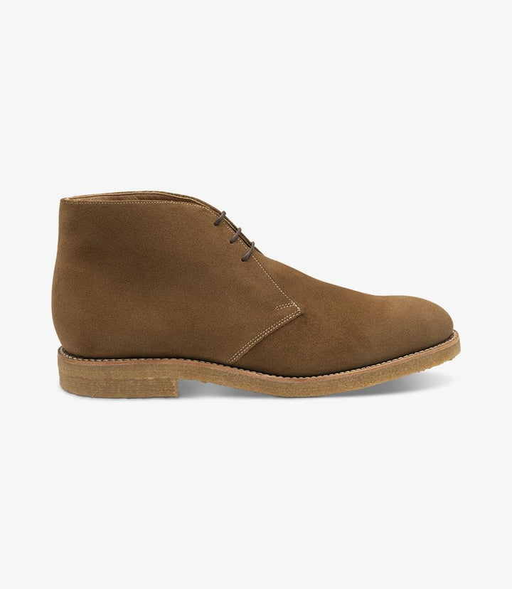 The side profile of the Loake Rivington Tan Chukka Boot highlights its sleek and sophisticated design. The rich tan suede leather has a soft, inviting texture, enhancing the boot's luxurious appearance. The Goodyear welted crepe sole is visible at the bottom, providing a modern touch and a reliable grip. The rounded toe shape contributes to the boot’s classic aesthetic, making it an ideal choice for both casual and formal settings.