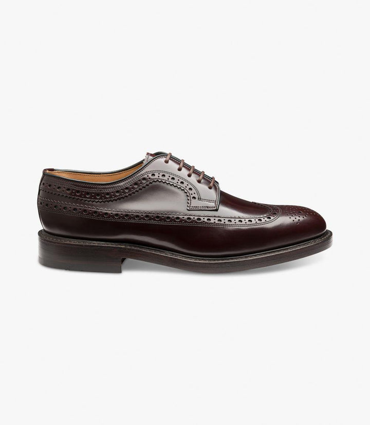 The Loake Royal Burgundy Derby Brogue is shown from the side, highlighting its rich burgundy leather with classic brogue detailing. The intricate punched holes and wingtip design extend from the toe to the sides, adding a sophisticated and traditional touch. The double leather sole and Goodyear welted construction are visible, showcasing the shoe’s durability and premium craftsmanship.