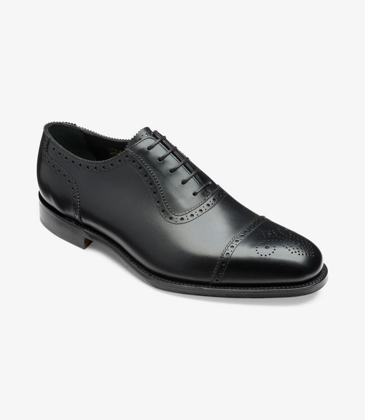 From an angled perspective, the shoe reveals the delicate punch-out detailing on the wing cap, enhancing its semi-brogue design. The smooth transition from the leather upper to the sleek sole is evident, demonstrating the craftsmanship that ensures both style and comfort. The slightly chisel-shaped toe adds a modern edge to the classic brogue design.