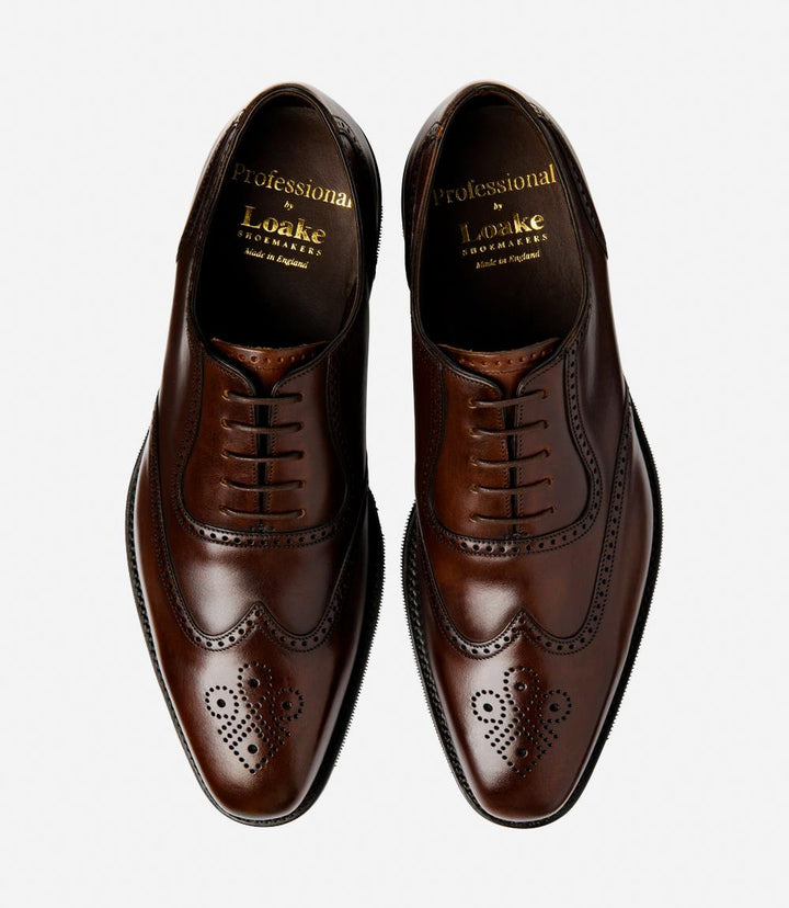 A bird's-eye view captures the symmetry and elegance of the Loake Tay Dark Brown Polished Oxford Semi-Brogues. The matching pair exudes refinement with their polished leather construction and timeless semi-brogue detailing. Designed for comfort and style, these shoes are a testament to British craftsmanship and luxury.